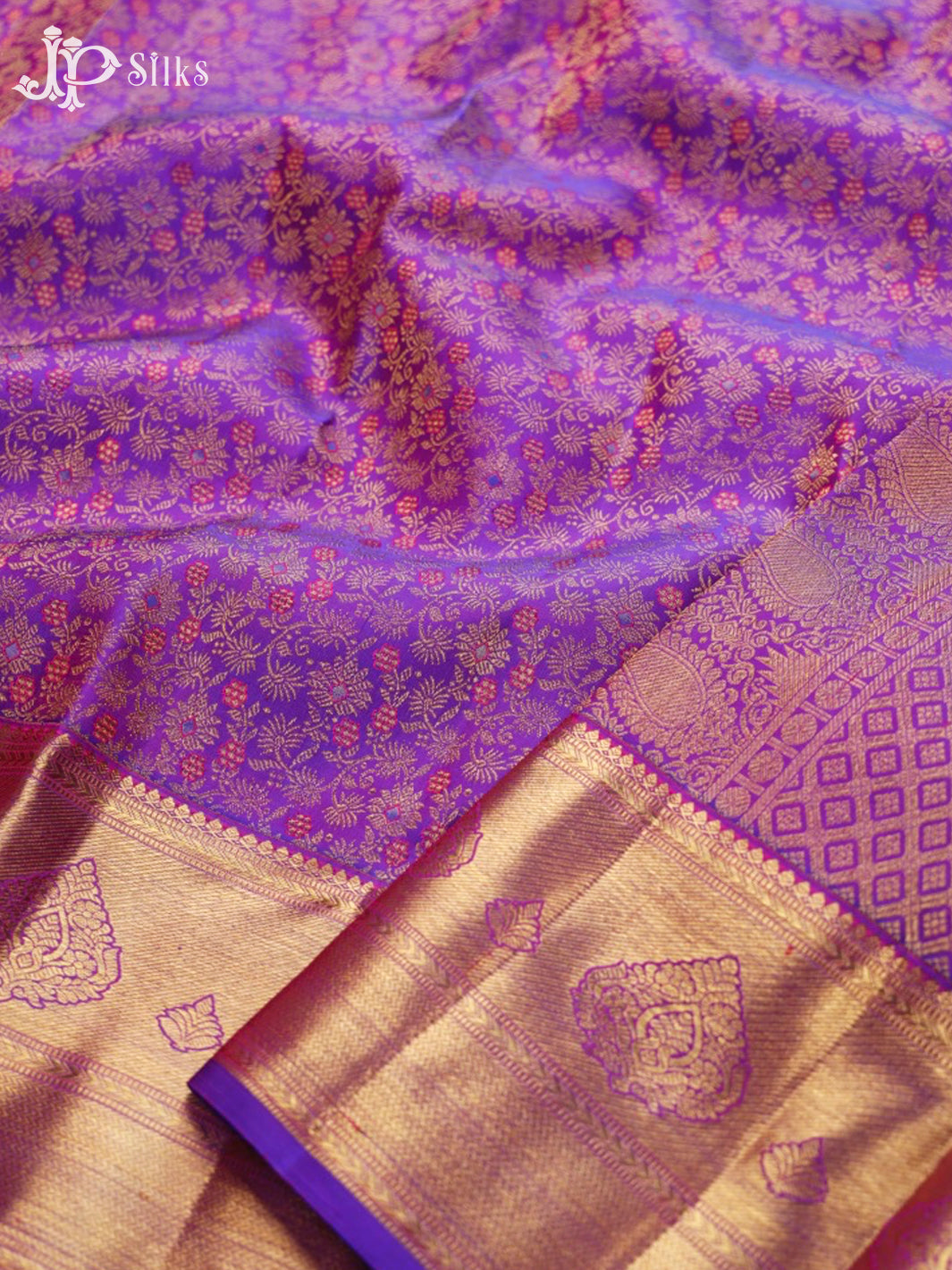 Purple and gold saree with intricate patterns, featuring the brand 'JP Silks'.
