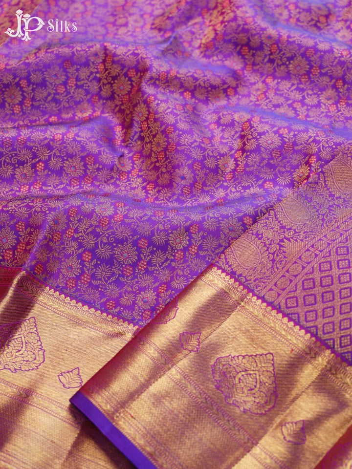 Purple and gold saree with intricate patterns, featuring the brand 'JP Silks'.